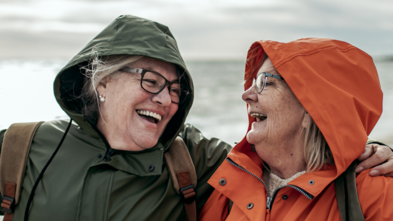 pareja de adultos mayores riéndose en la playa