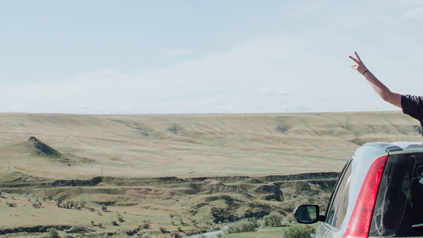 Mujer con auto contemplando la vista al desierto