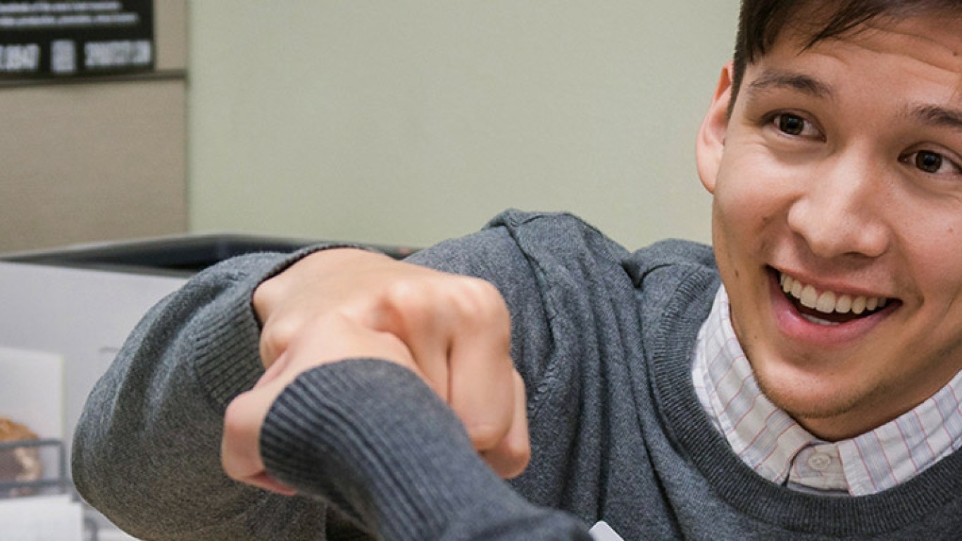 Man fist bumping woman in office setting