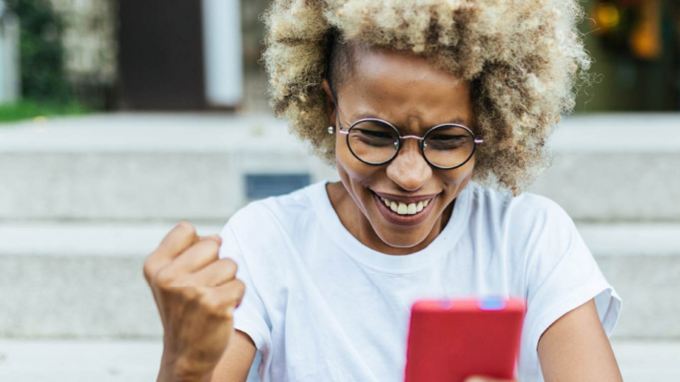 una mujer sonriente mirando su teléfono 