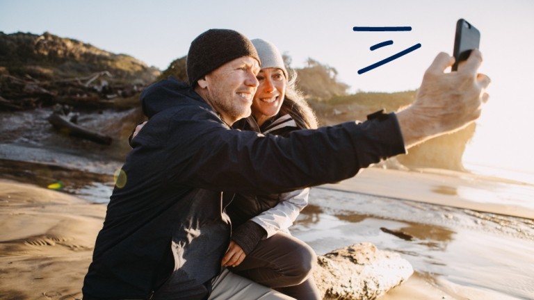 Couple takes a selfie by the ocean.