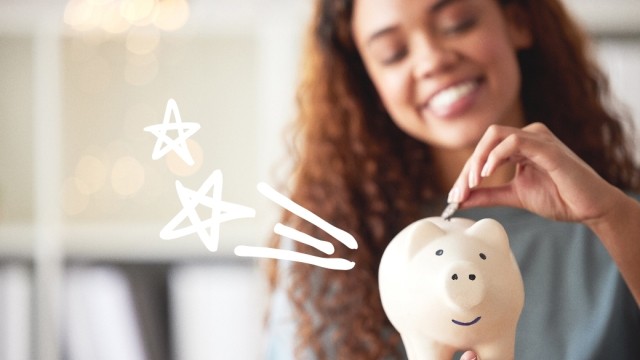 woman putting money in piggy bank