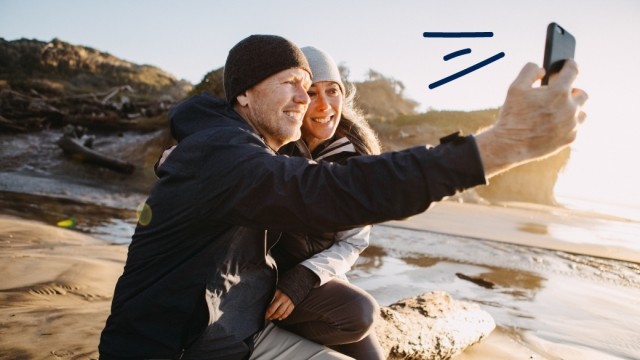 Couple takes a selfie by the ocean.