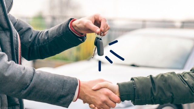 Some hands the keys to a new car owner