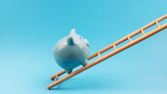 Light blue background with white porcelain piggybank climbing up a ladder.