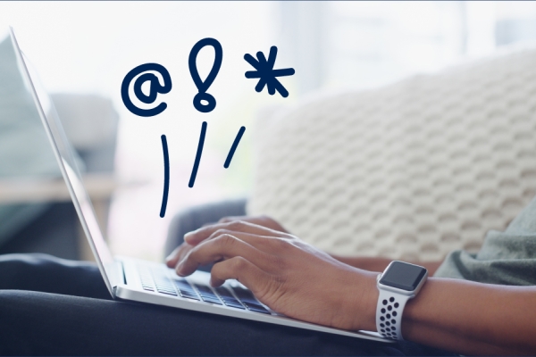 Hands typing on a laptop with doodles in the air. 