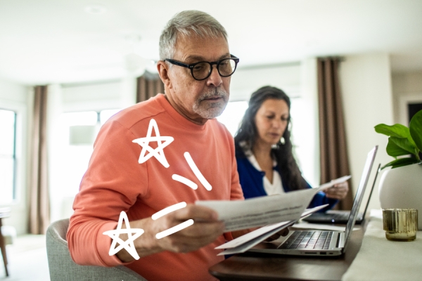 Man looks at bills with doodles in the air. 
