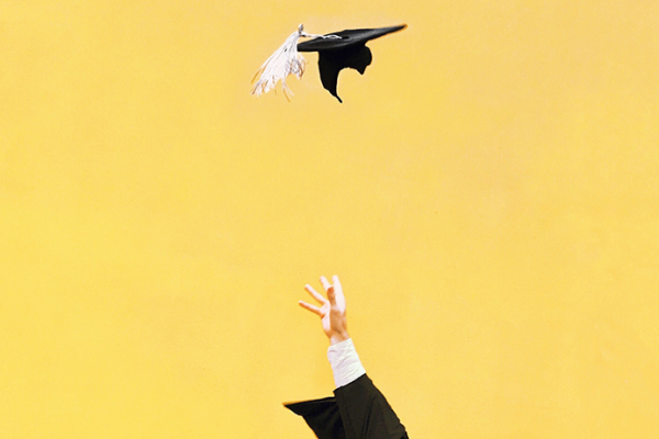 Hand throwing graduation cap into the air with a yellow background