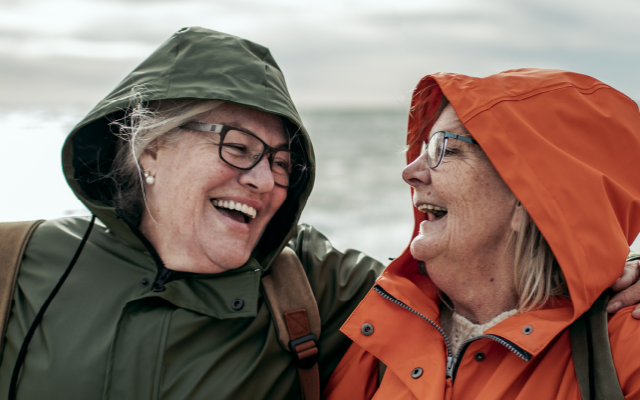 pareja de adultos mayores riéndose en la playa