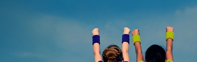 children with hands raised in a triumphant manner