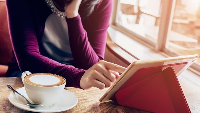 Una mujer en una cafetería con una tableta