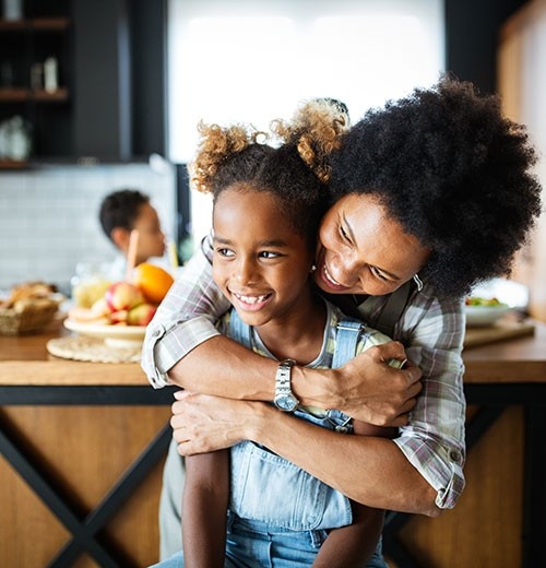 Una madre e hija se abrazan en la cocina